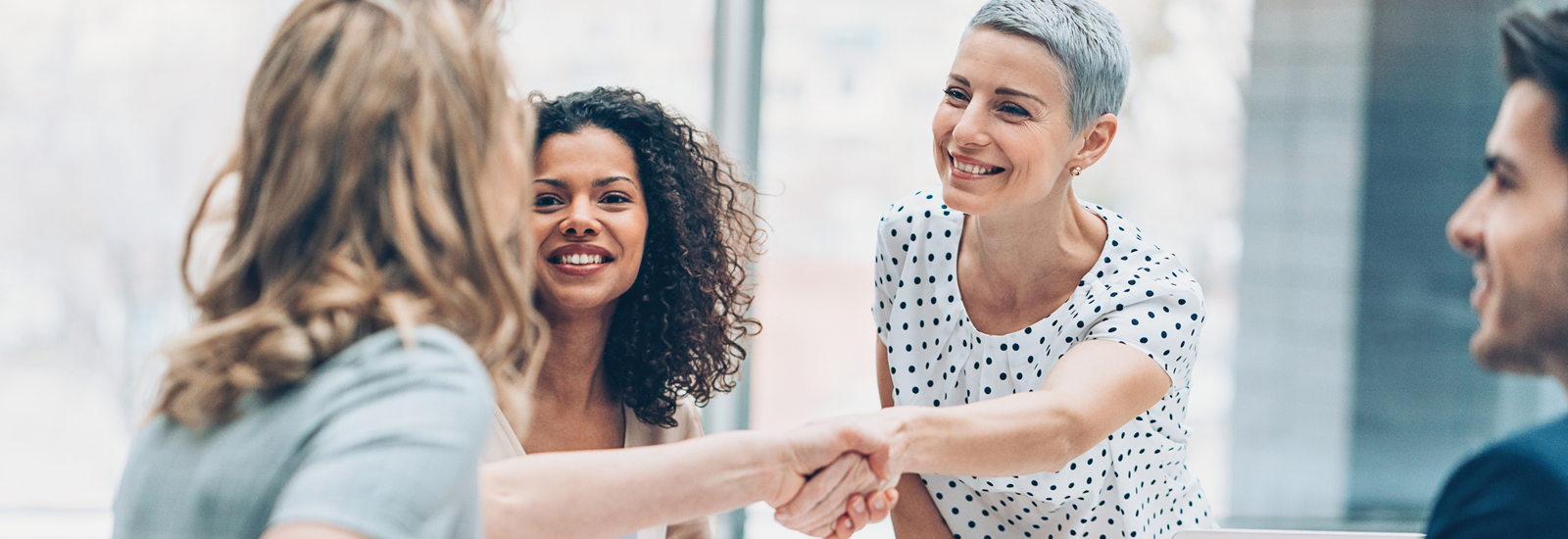 associates smiling while shaking hands