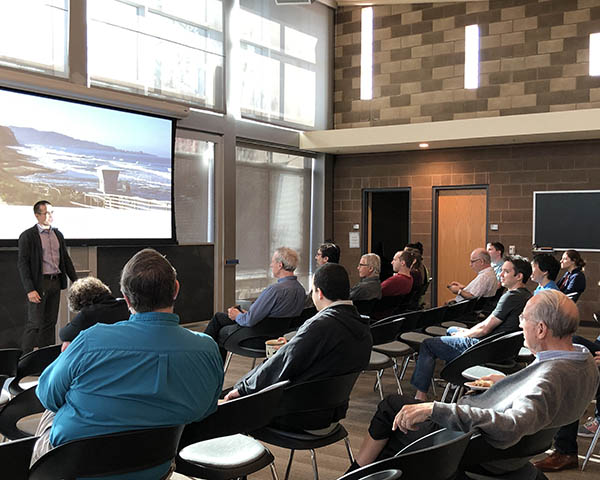 Photo of presenter presenting slides to small audience