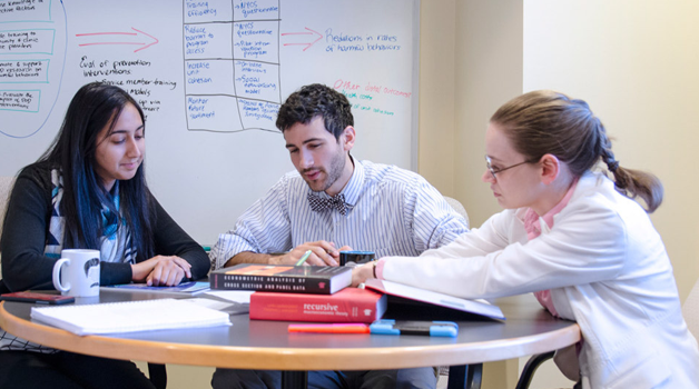 SAC staff discussing research at a table